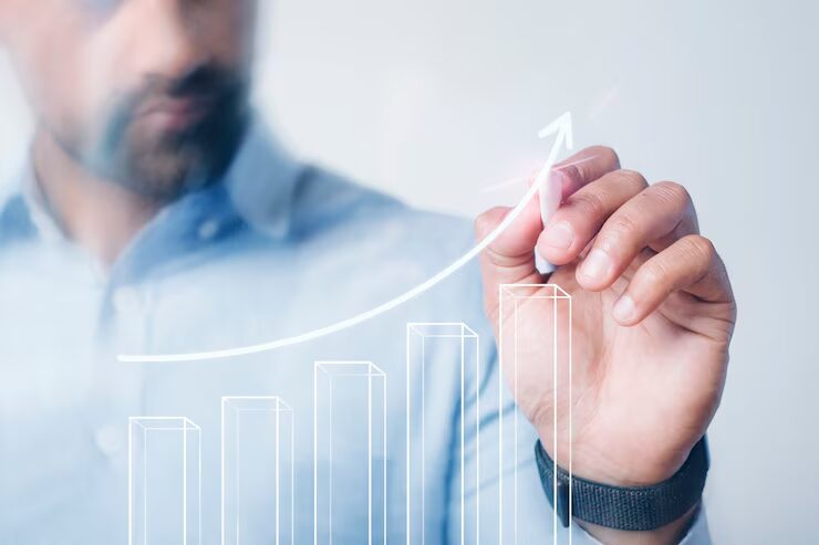 Businessman drawing a graph showing upward business growth with a focus on staying ahead of competitors.